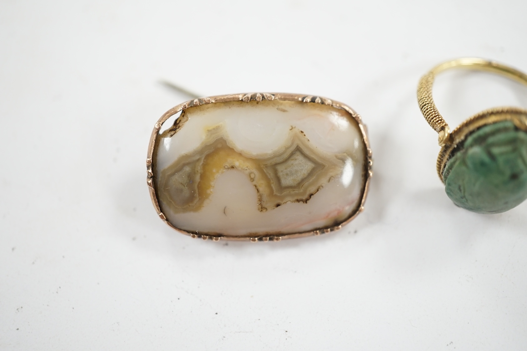 An antique yellow metal 'Scarab' ring and a banded agate set brooch. Condition - poor to fair